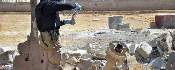 Pripadnik istražnog tima UN uzima uzorke peska u blizini jedne od hemijskih raketa koja je ispaljena u Damasku - Sputnik Srbija