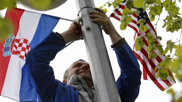 Čovek postavlja zastev Hrvatske i SAD na banderu - Sputnik Srbija