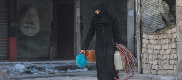 A woman walks in a residential area of Aleppo, a city divided by a front line (File) - Sputnik Србија