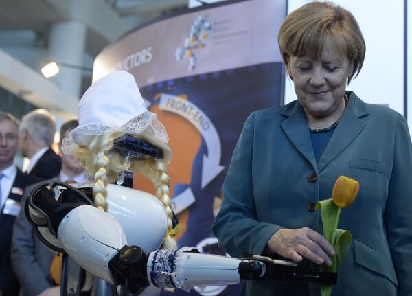 Канцеларка Немачке Ангела Меркел узима цвет од робота на Хановерском сајму - Sputnik Србија