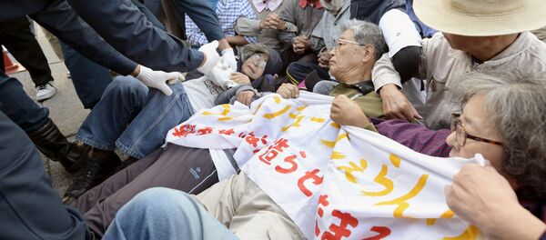 Protesters lie on the ground as they try to block work on a contentious U.S. air base in front of the gate of the U.S. Marine Corps Camp Schwab in Nago on the southern Japanese island of Okinawa - Sputnik Србија