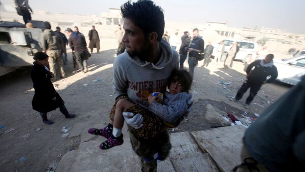 Irački vojnik sa ranjenom devojčicom u Mosulu tokom borbi protiv DAEŠ-a - Sputnik Srbija