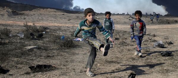 Деца играју фудбал у близини нафтних поља које је спалио ДАЕШ, јужно од Мосула - Sputnik Србија