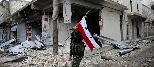 Сиријски војник са подигнутом заставом Сирије у Алепу - Sputnik Србија