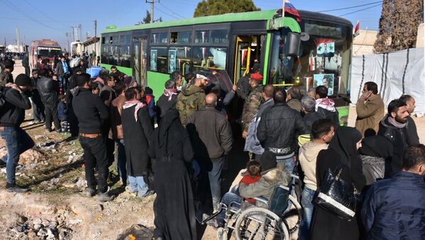 Sirijci koji napuštaju Alep ulaze u autobus u selu Aziza - Sputnik Srbija