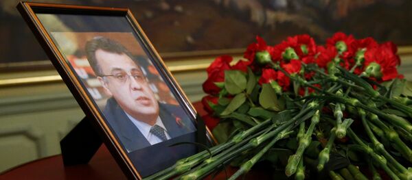 Цвеће постављено испред портрета убијеног амбасадора Русије у Турској Андреја Карлова у Министарству спољних послова Русије у Москви - Sputnik Србија