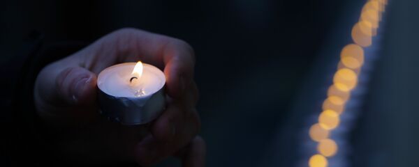 Čovek pali sveću ispred zgrade ansambla Aleksandrov u Moskvi - Sputnik Srbija