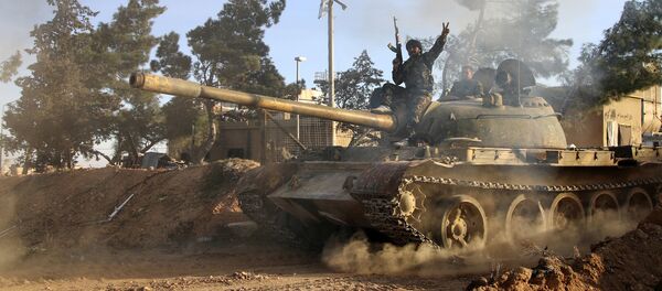 Припадник сиријске војске седи на тенку у сиријској провинцији Рака - Sputnik Србија