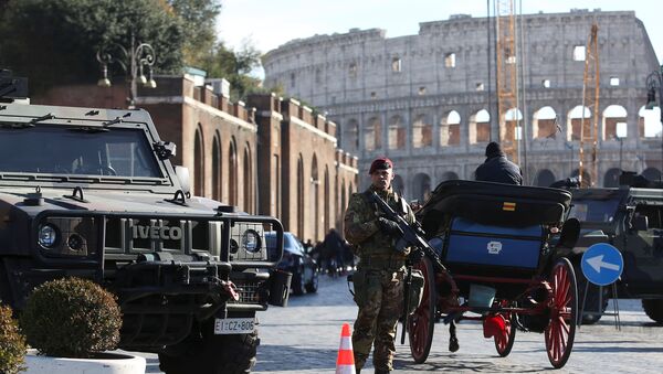 Наоружани припадник војске Италије патролира испред Колосеума док су у Риму уведене појачане безбедносне мере пред прославу Нове године - Sputnik Србија
