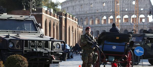 Наоружани припадник војске Италије патролира испред Колосеума док су у Риму уведене појачане безбедносне мере пред прославу Нове године - Sputnik Србија