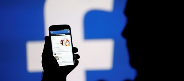 Silueta čoveka ispred ekrana sa logom Fejsbuka - Sputnik Srbija