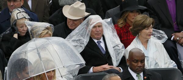 Bivši američki predsednik Džordž V. Buš štiti se kabanicom od kiše na ceremoniji inauguracije Donalda Trampa u Vašingtonu Bivši američki predsednik Džordž V. Buš štiti se kabanicom od kiše na ceremoniji inauguracije Donalda Trampa u Vašingtonu - Sputnik Srbija