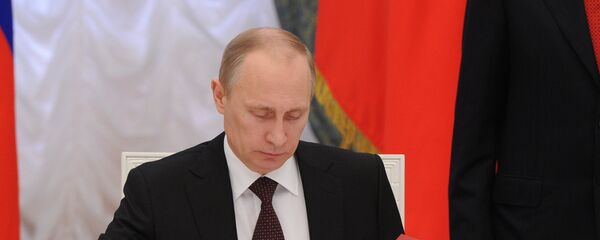 Predsednik Rusije Vladimir Putin potpisuje ukaz - Sputnik Srbija