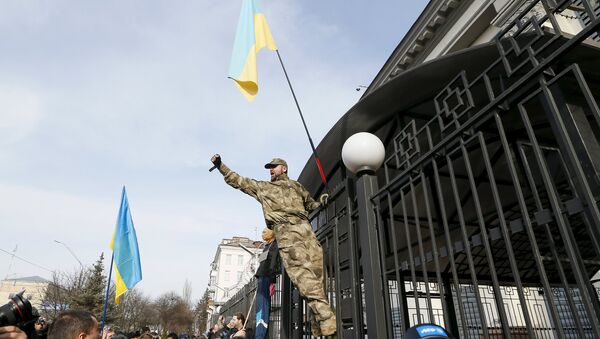 Демонстрант се пење на ограду амбасаде Русије у Кијеву током протеста за ослобађање украјинског пилота Надежде Савченко - Sputnik Србија