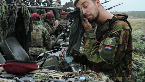 A Royal Dutch Army soldier wipes his face after the NATO Noble Jump exercise on a training range in Poland. - Sputnik Srbija