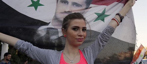 Devojka u Siriji sa zastavom Sirije na kojoj je lik predsednika Bašara el Asada - Sputnik Srbija