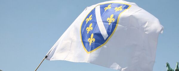 Zastava Bosne i Hercegovine ispred gomile cipela i logoa UN ispred Brandenburške kapije u Berlinu. - Sputnik Srbija