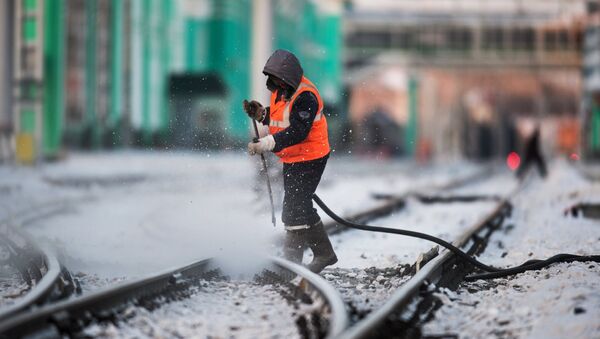 Радник чисти пругу на железничкој станици у Омску - Sputnik Србија
