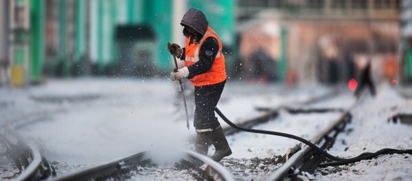 Радник чисти пругу на железничкој станици у Омску - Sputnik Србија