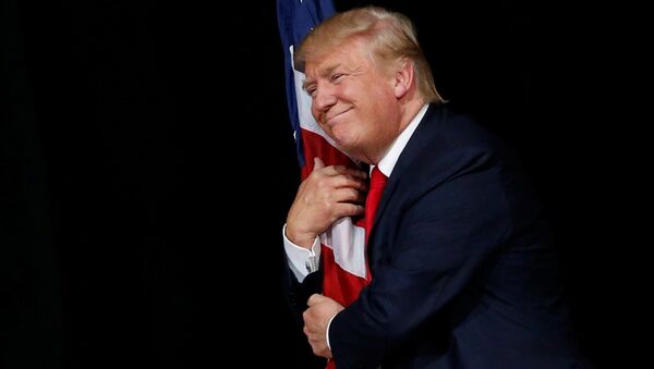 Donald Tramp grli američku zastavu na mitingu u Tampi - Sputnik Srbija