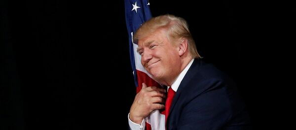 Доналд Трамп грли америчку заставу на митингу у Тампи Доналд Трамп грли америчку заставу на митингу у Тампи - Sputnik Србија