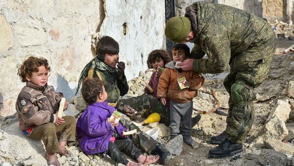 Сиријски војник у Алепу помаже деци - Sputnik Србија