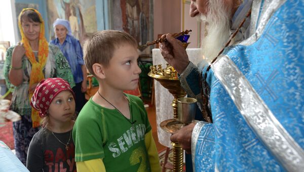 Seoski sveštenik pričešćuje decu - Sputnik Srbija