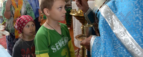 Seoski sveštenik pričešćuje decu - Sputnik Srbija