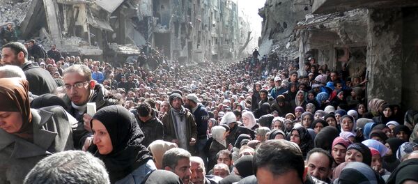 Палестинске избеглице и становници опкољеног избегличког кампа Јармук у близини Дамаска, стоје у реду за хуманитарну помоћ - Sputnik Србија