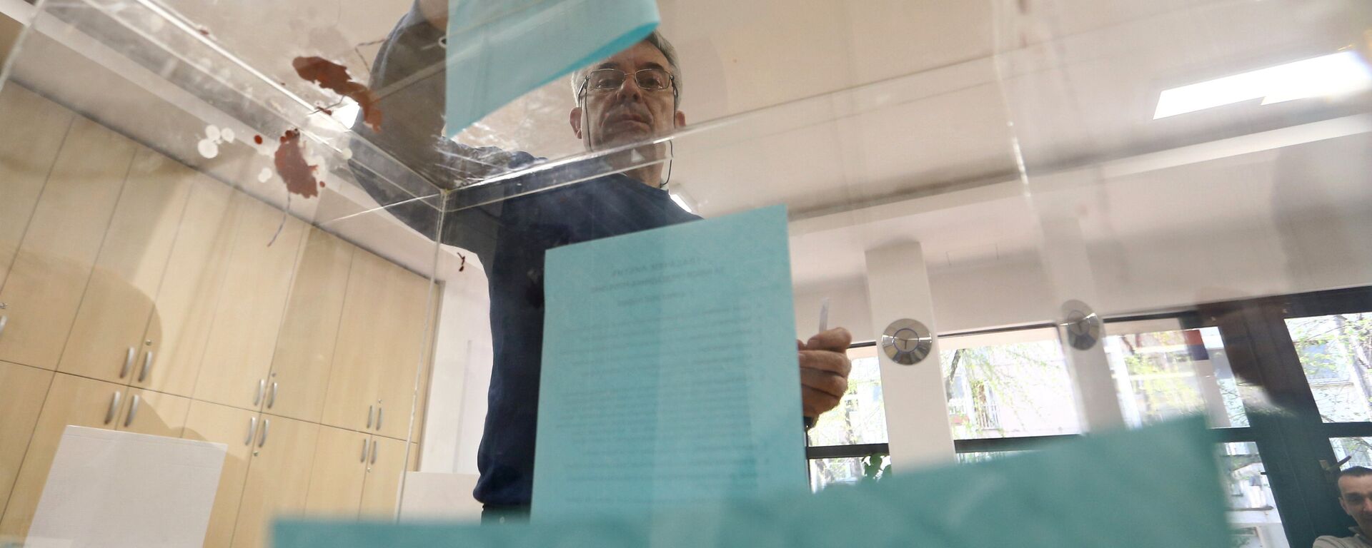 Čovek ubacuje listić u glasačku kutiju na predsedničkim izborima u Srbiji - Sputnik Srbija, 1920, 17.10.2021