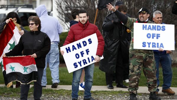 Људи носе транспаренте на протесту против америчког ракетног напада на сиријску војну базу у Алентауну - Sputnik Србија