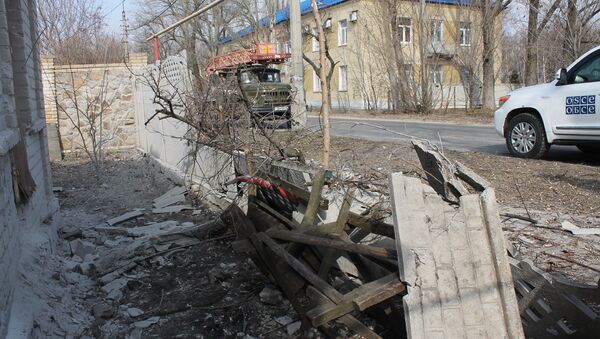 Vozilo delegacije OEBS-a u blizini kuće oštećene u granatiranju u Donjeckoj oblasti. - Sputnik Srbija