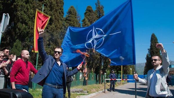 Грађански активиста Марко Милачић испред затвора у Спужу пали заставу НАТО-а - Sputnik Србија