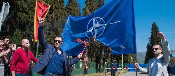 Грађански активиста Марко Милачић испред затвора у Спужу пали заставу НАТО-а - Sputnik Србија