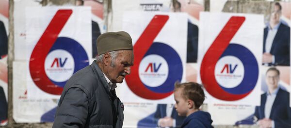 Čovek šeta pored plakata Aleksandra Vučića - Sputnik Srbija