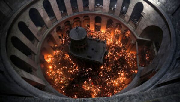 Православни верници пале свеће након силаска благодатног огња у храму Христовог гроба у Јерусалиму - Sputnik Србија