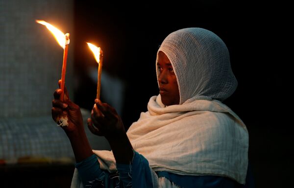 Етиопска православна верница током вечерње ускршње молитве у цркви Медхане Алем у Адис Абеби, Етиопија - Sputnik Србија