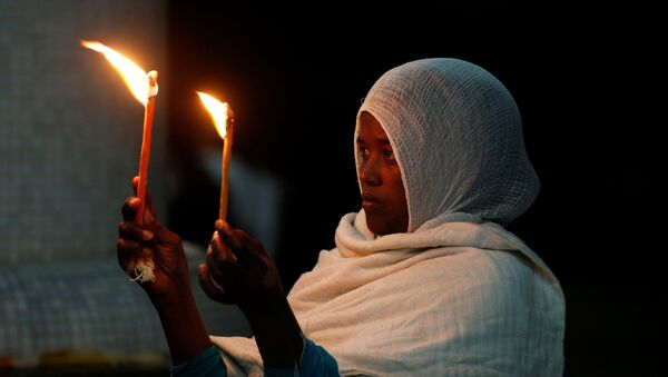 Etiopska pravoslavna vernica tokom večernje uskršnje molitve u crkvi Medhane Alem u Adis Abebi, Etiopija - Sputnik Srbija
