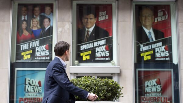 Čovek prolazi pored sedišta kompanije Njuz na kojoj su nalepljeni posteri sa likom bivšeg novinara televizije Foks Njuz Bila O'Rajlija - Sputnik Srbija