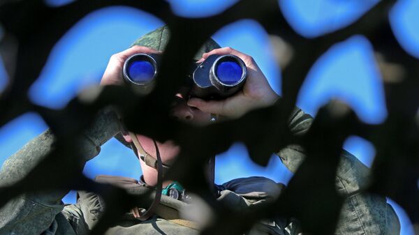 Vojnik gleda kroz dvogled na vojnoj vežbi na poligonu u blizini granice sa Litvanijom - Sputnik Srbija