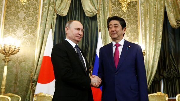 Predsednik Rusije Vladimir Putin rukuje se sa premijerom Japana Šinzom Abeom pre sastanka u Moskvi - Sputnik Srbija