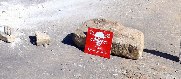 Ljudi na motoru prolaze pored znaka za opasnost u blizini mesta bombaškog napada u gradu Han Šeihun u Idlibu, u Siriji - Sputnik Srbija