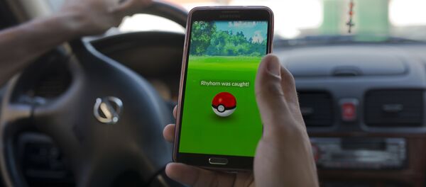 Čovek igra Pokemon go dok vozi automobil. - Sputnik Srbija
