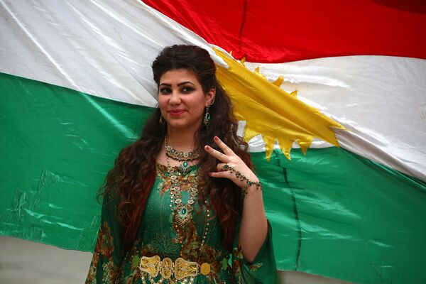 A Syrian-Kurdish model poses in front of Kurdish flag. - Sputnik Србија