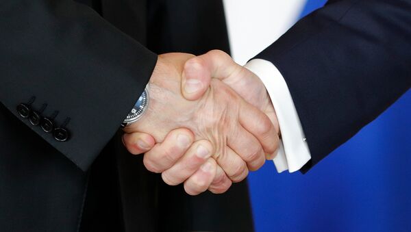 Ruski predsednik Vladimir Putin i francuski predsednik Emanuel Makron se rukuju - Sputnik Srbija