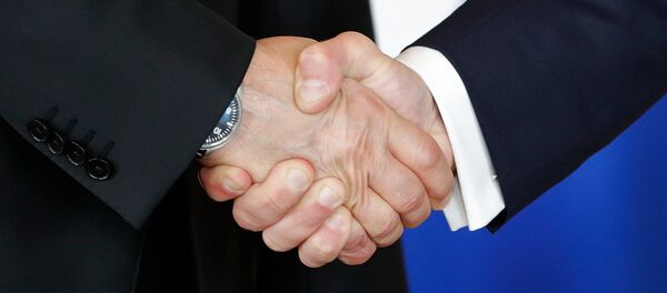Ruski predsednik Vladimir Putin i francuski predsednik Emanuel Makron se rukuju - Sputnik Srbija