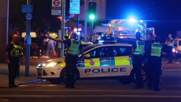 Припадници полиције стоје поред возила након напада у Лондону - Sputnik Србија