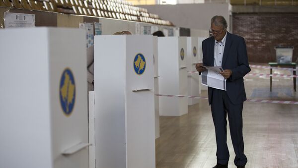 Човек гледа у гласачки листић пре гласања на парламентарним изборима на Космету у Приштини - Sputnik Србија