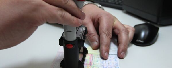 Pripadnik beloruske pogranične službe stavlja pečat u pasoš na belorusko-poljskoj granici Pripadnik beloruske pogranične službe stavlja pečat u pasoš na belorusko-poljskoj granici - Sputnik Srbija