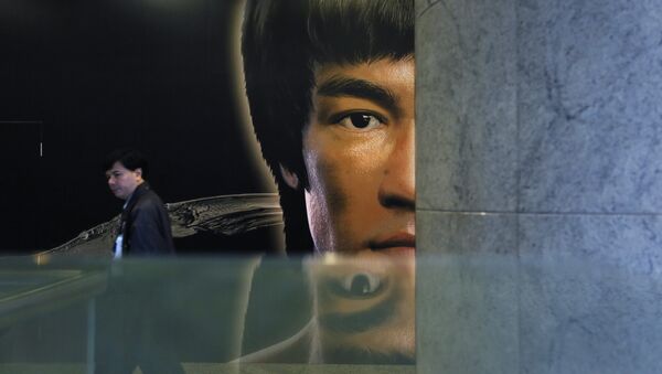 Човек пролази поред постера за Брус Лијеву изложбу у Хонг Конгу. - Sputnik Србија